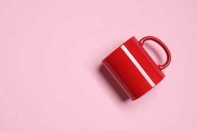Photo of Red ceramic mug on pink background, top view. Space for text