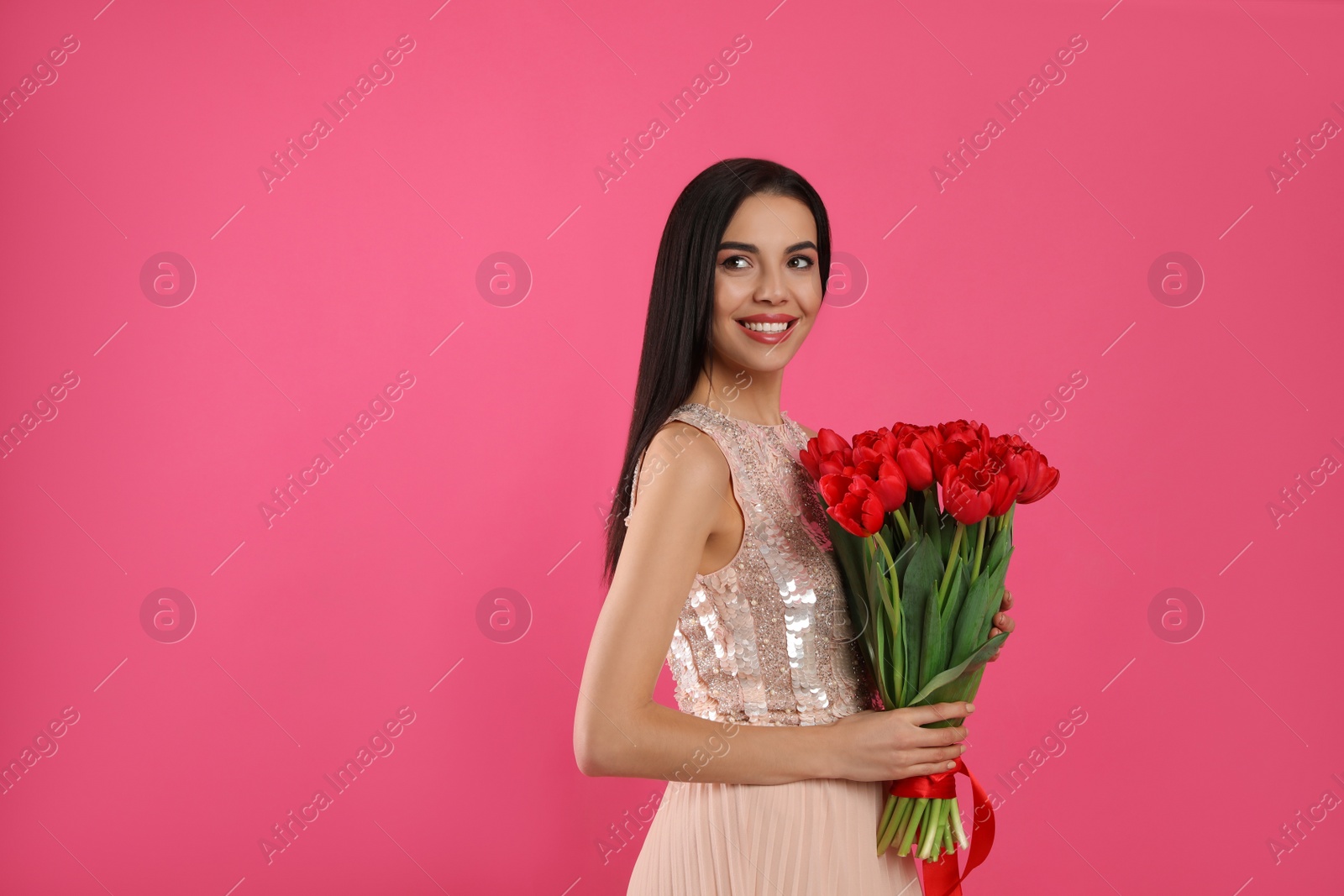 Photo of Happy woman with red tulip bouquet on pink background, space for text. 8th of March celebration