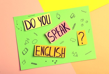 Photo of Note with question Do You Speak English on color background, top view