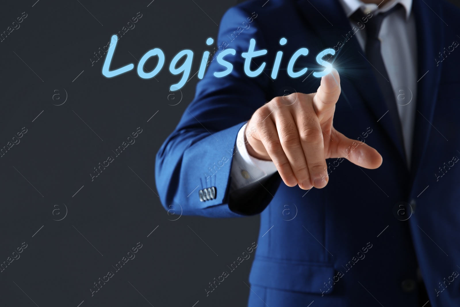 Image of Businessman pointing at word LOGISTICS on virtual screen against dark background, closeup 