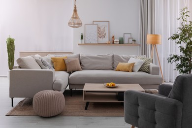 Stylish living room interior with comfortable grey sofa and coffee table