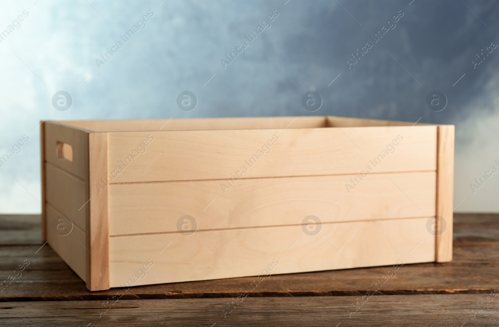 Photo of Wooden crate on table against color background