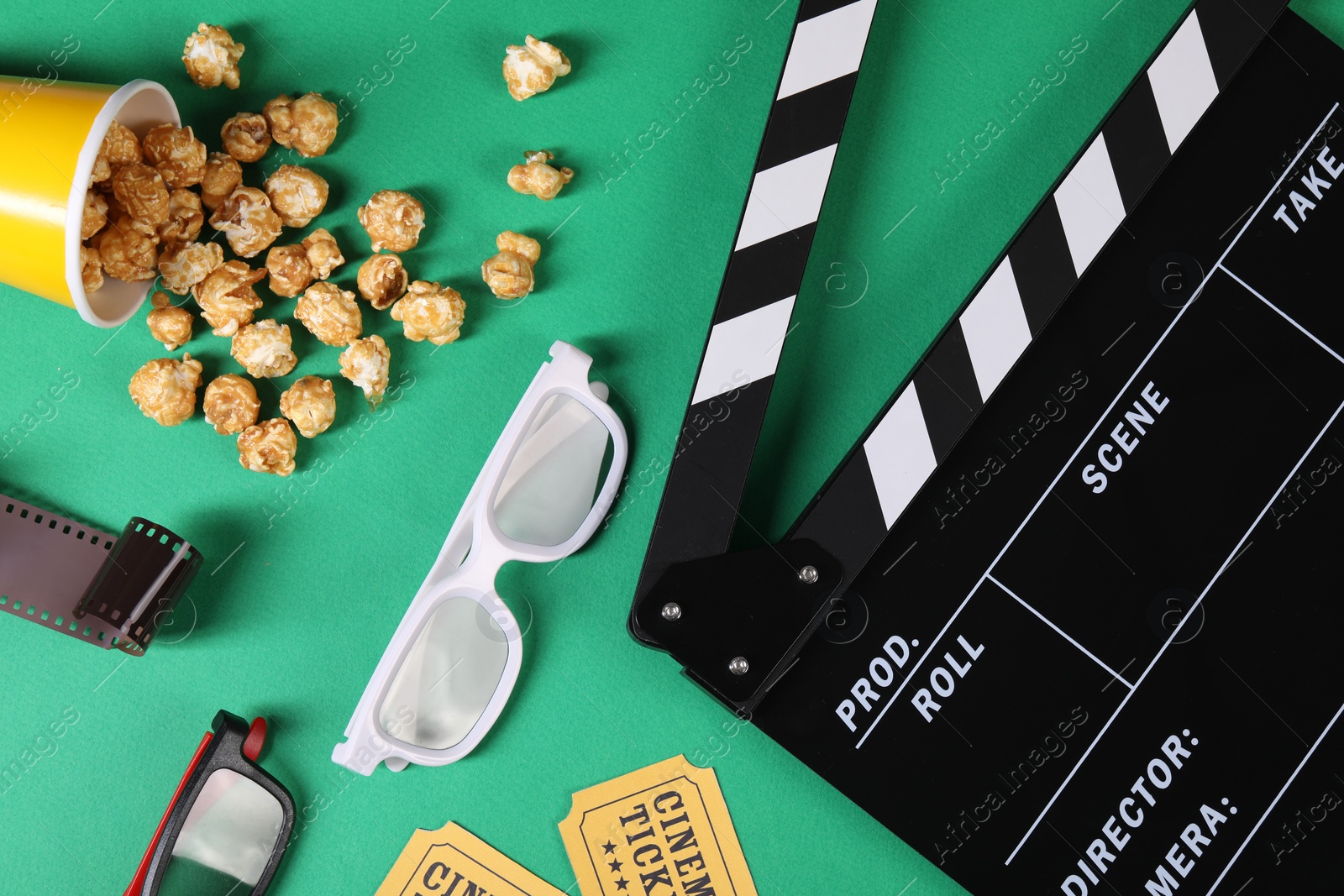 Photo of Flat lay composition with clapperboard, movie tickets and 3D glasses on green background