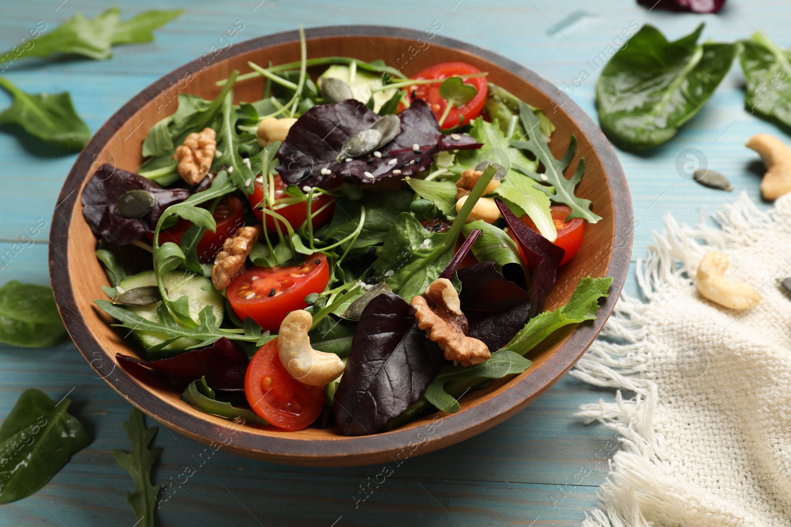 Photo of Tasty fresh vegetarian salad on light blue wooden table, closeup