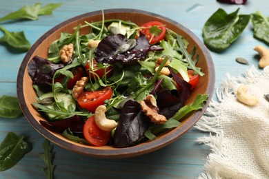 Photo of Tasty fresh vegetarian salad on light blue wooden table, closeup