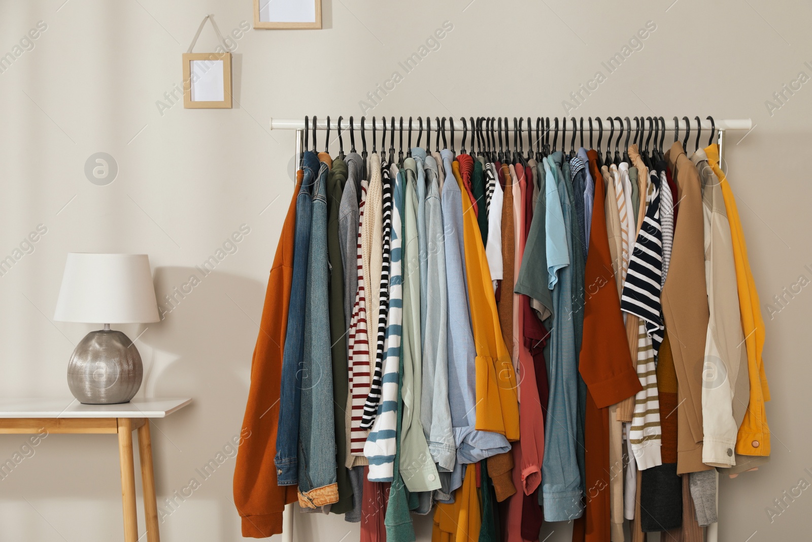 Photo of Rack with stylish clothes indoors. Fast fashion