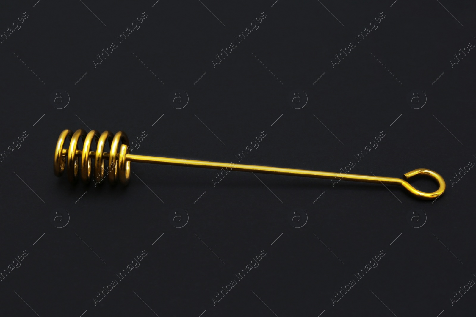 Photo of Elegant gold honey dipper on black background