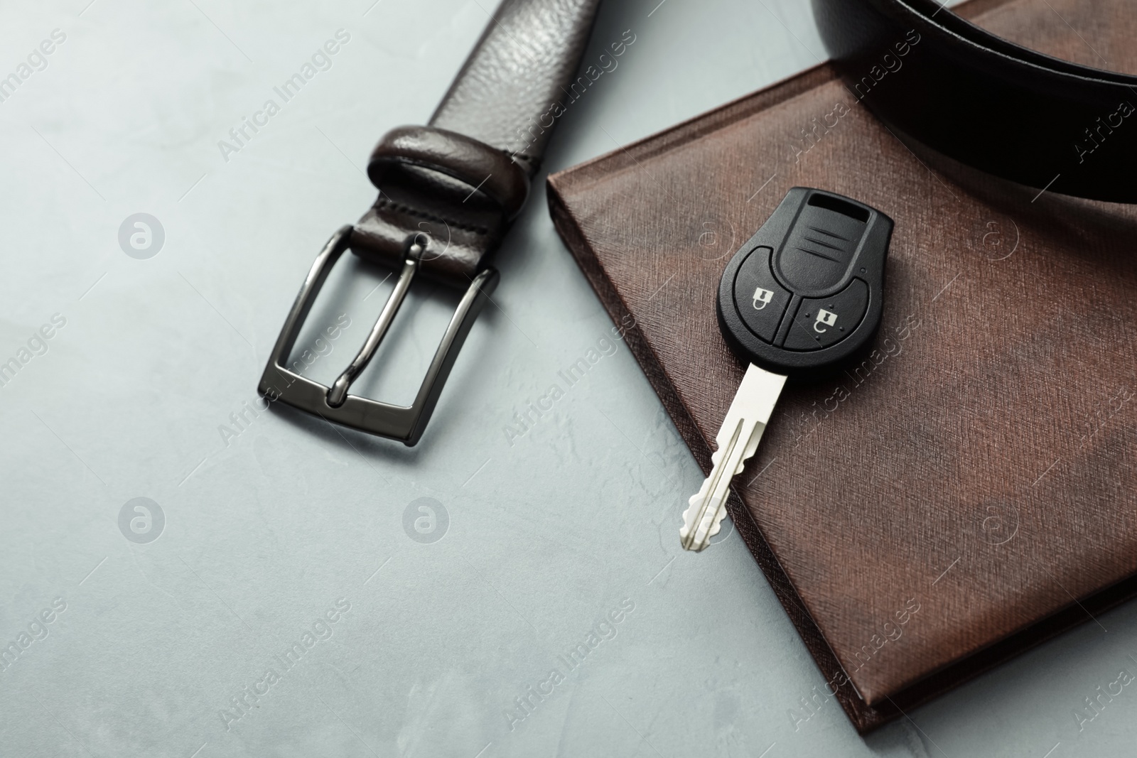 Photo of Composition with male accessories and car key on grey background