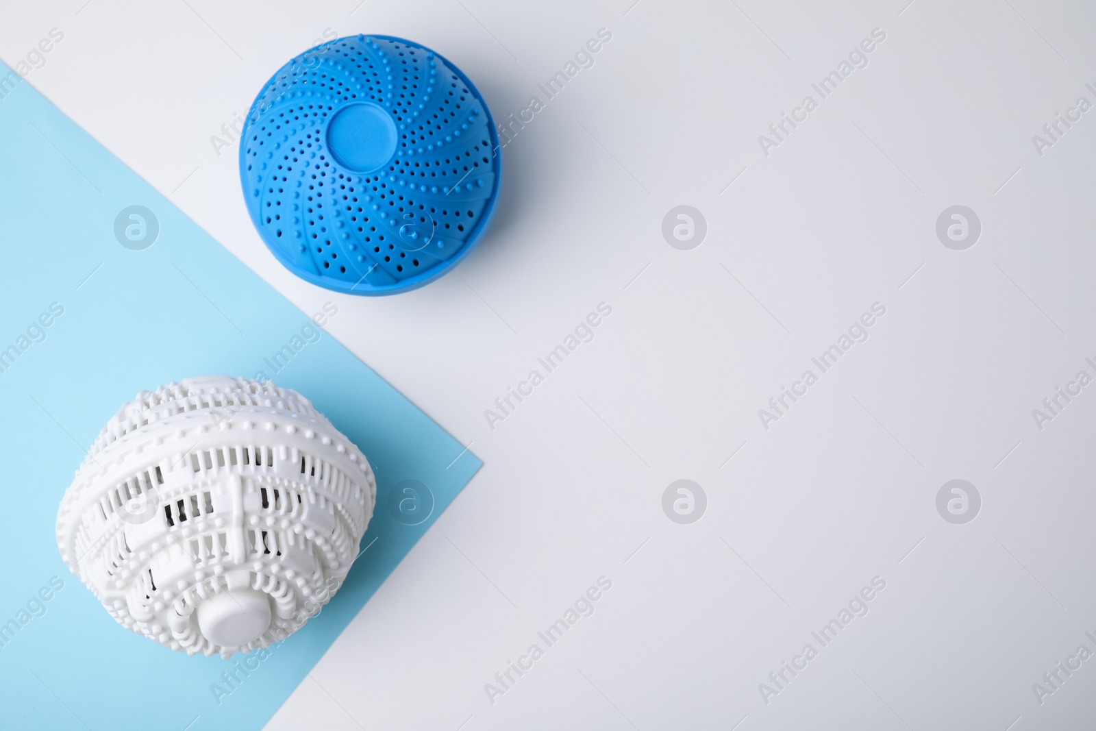 Photo of Laundry dryer balls on color background, flat lay. Space for text