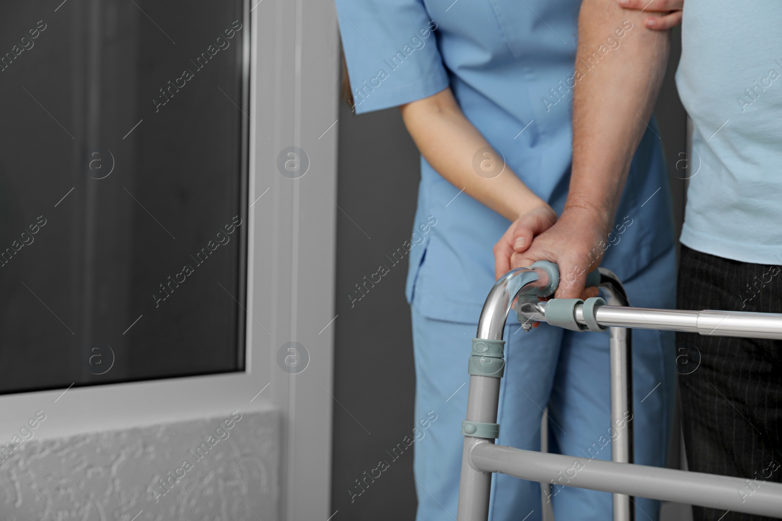 Photo of Nurse assisting senior patient with walker in hospital, closeup