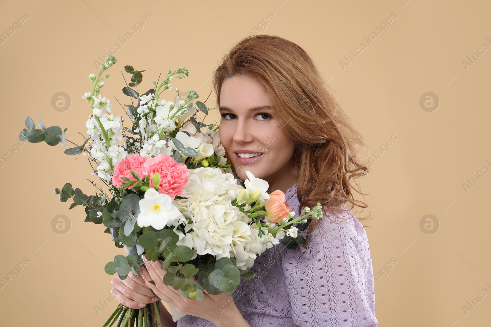 Photo of Beautiful woman with bouquet of flowers on beige background