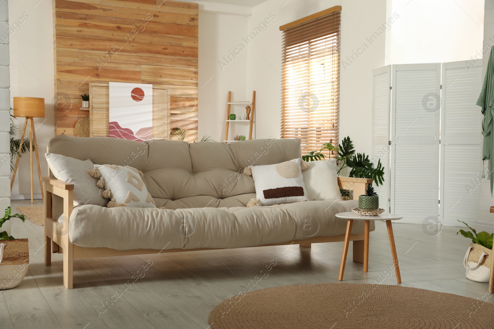 Photo of Light room interior with stylish wooden sofa and table. Idea for design
