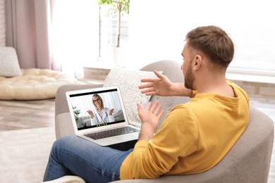 Image of Online medical consultation. Man having video chat with doctor via laptop at home