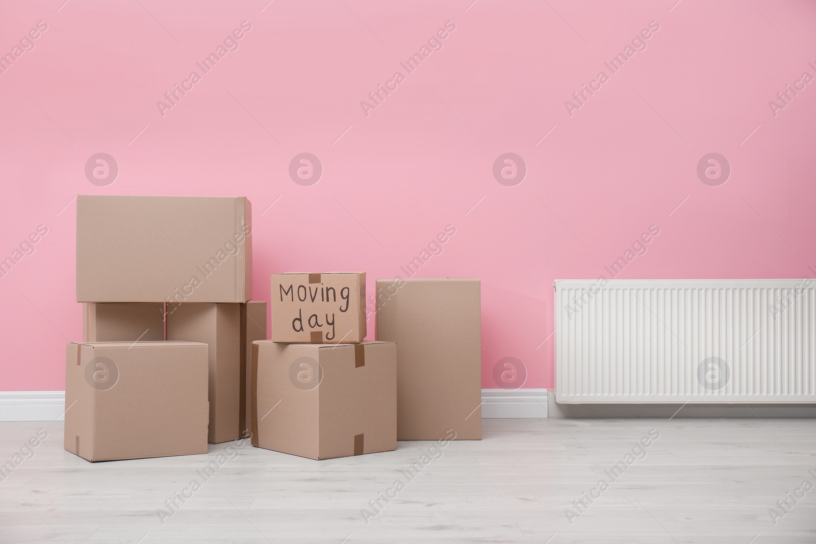 Photo of Cardboard boxes near color wall. Moving day