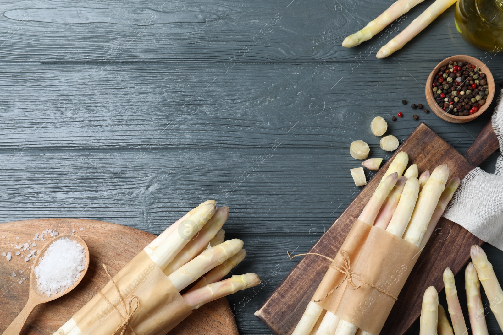 Photo of Flat lay composition with white asparagus on grey wooden table. Space for text