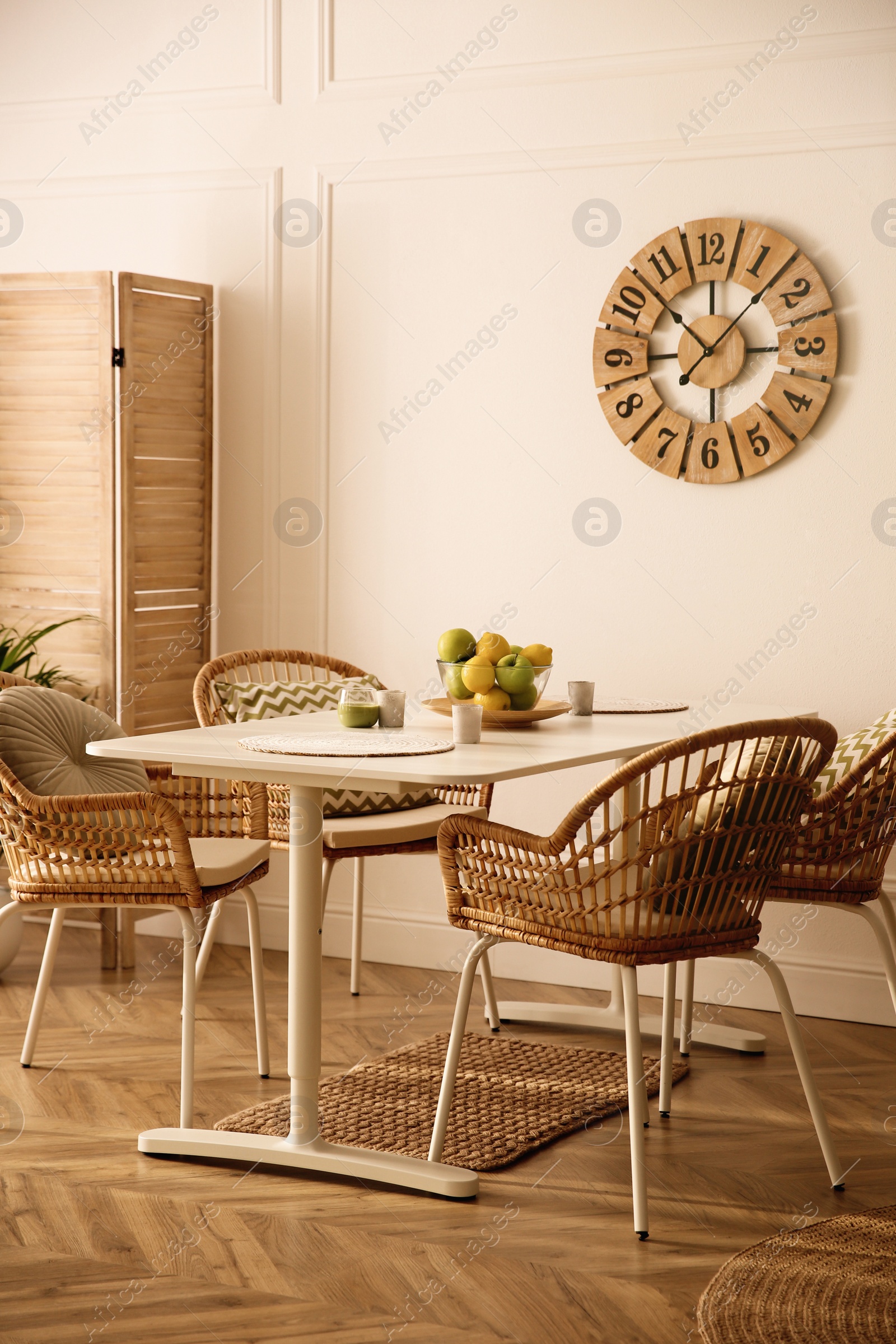 Photo of Stylish white dining table and wicker chairs in room. Interior design