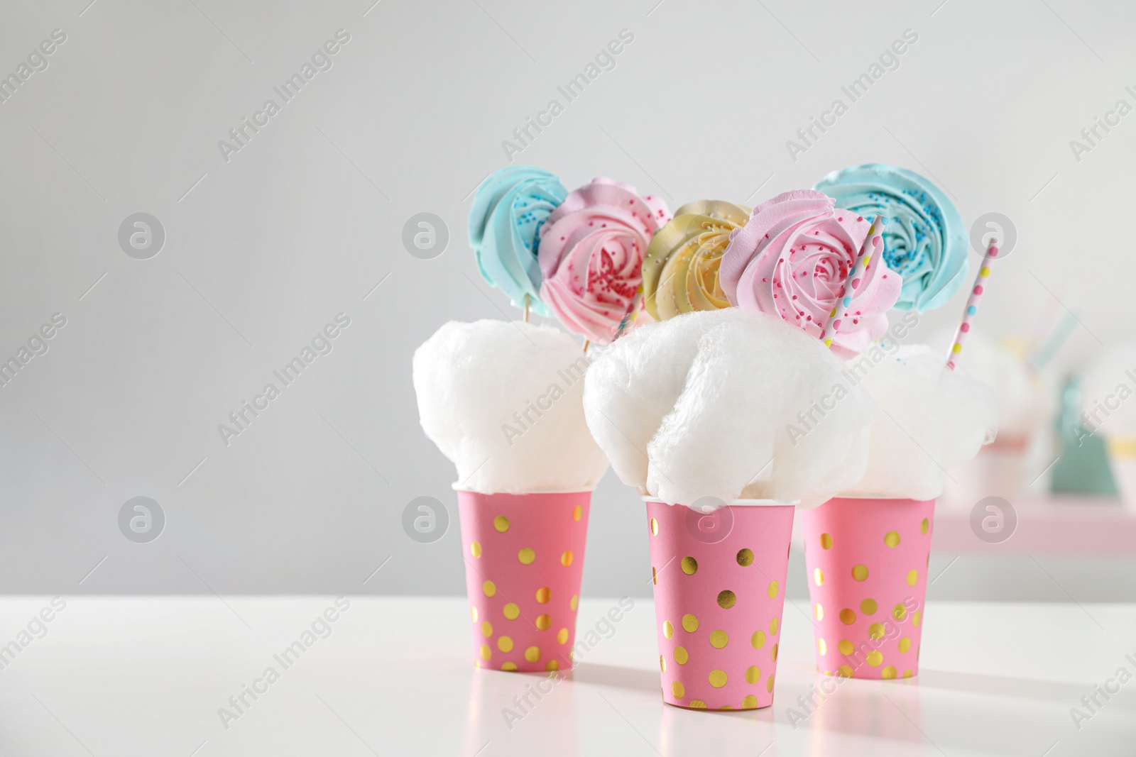 Photo of Cups with cotton candy dessert on table, space for text