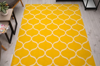 Photo of Stylish yellow carpet with pattern on floor in living room, above view