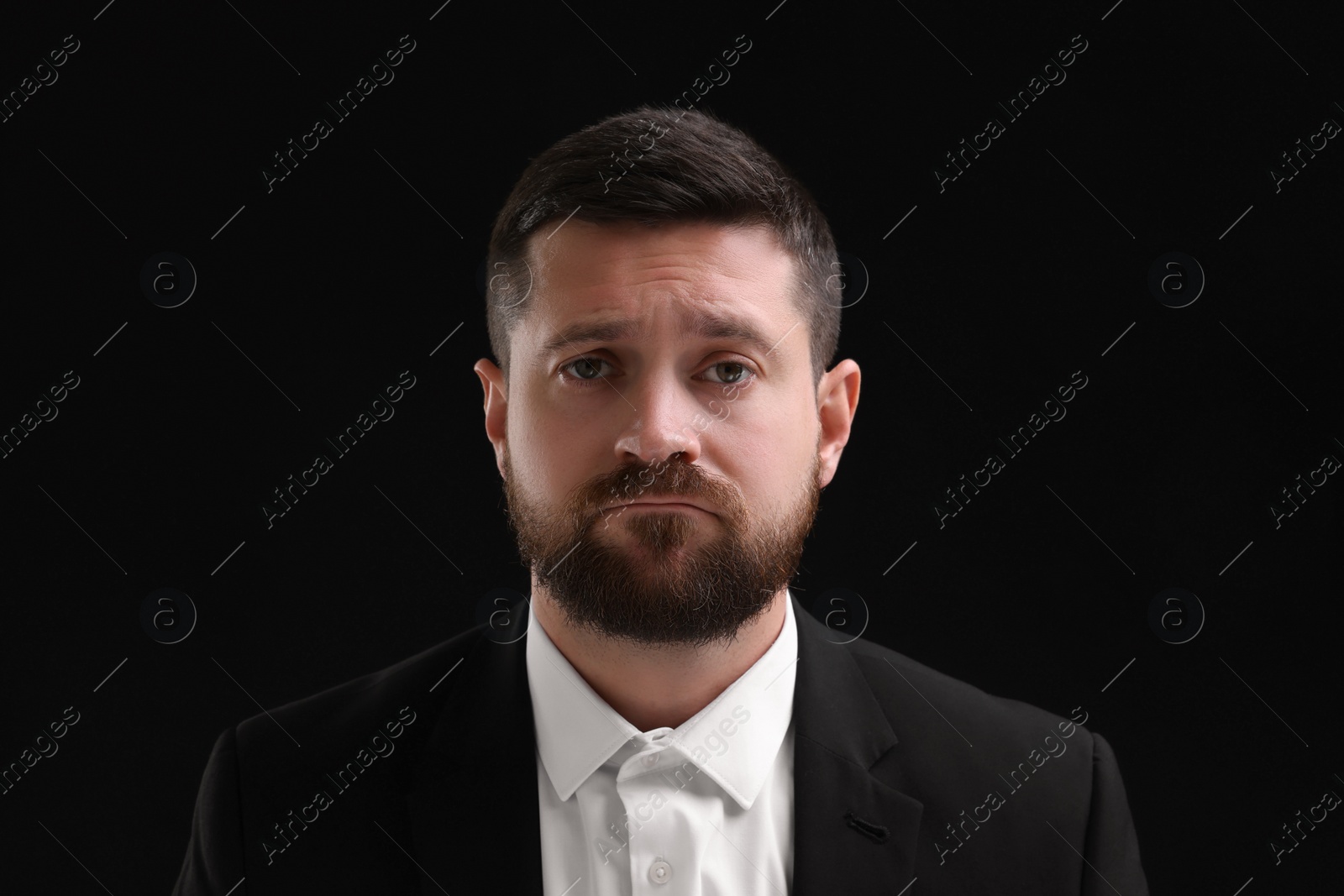 Photo of Personality concept. Sad man on black background