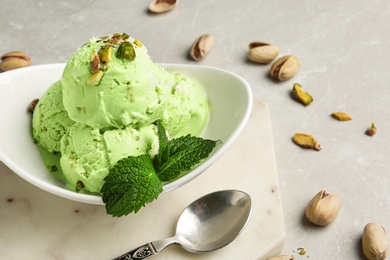 Photo of Tasty pistachio ice cream served on grey table