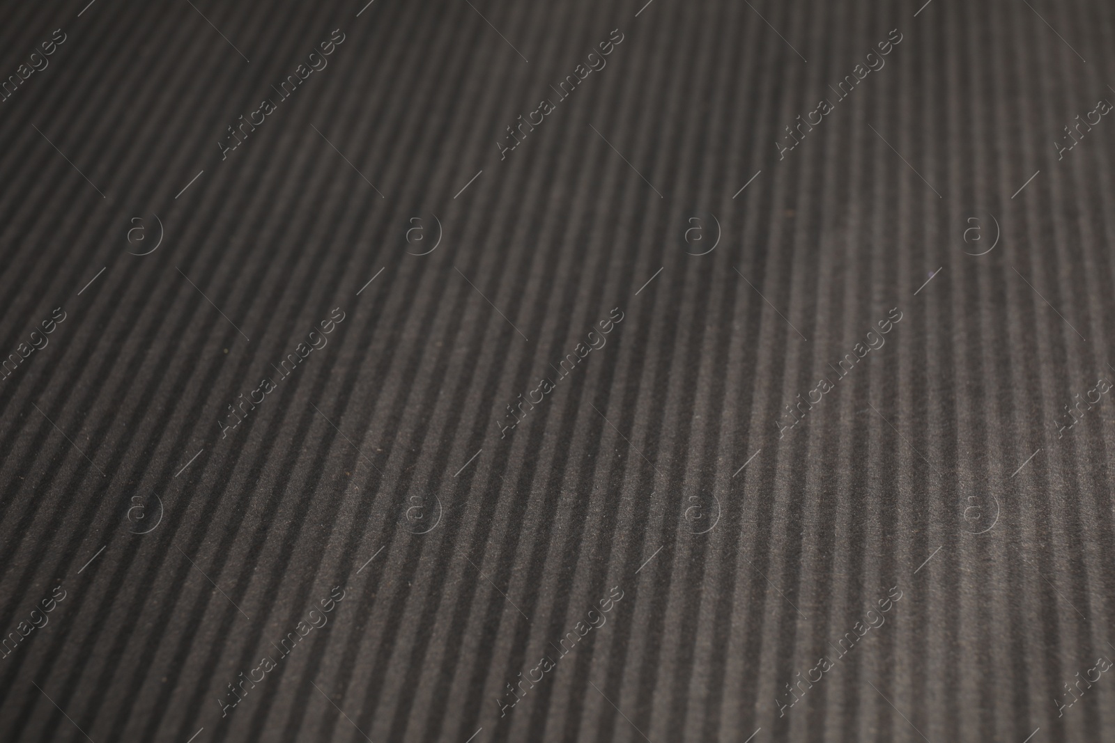 Photo of Dark grey corrugated sheet of cardboard as background, closeup