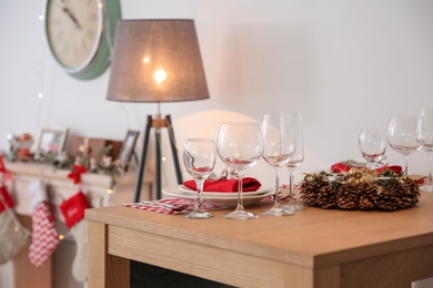Photo of Set of dinnerware and Christmas wreath on table indoors