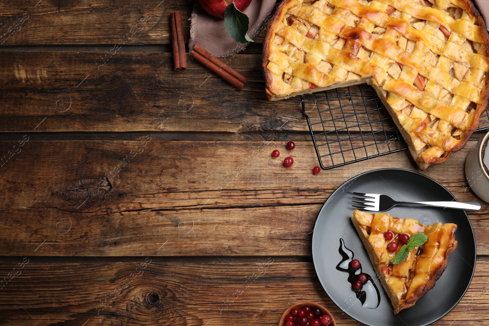 Photo of Slice of traditional apple pie with berries served on wooden table, flat lay. Space for text