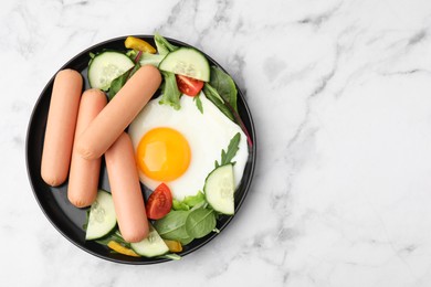 Photo of Delicious breakfast with boiled sausages and fried egg on white marble table, top view. Space for text