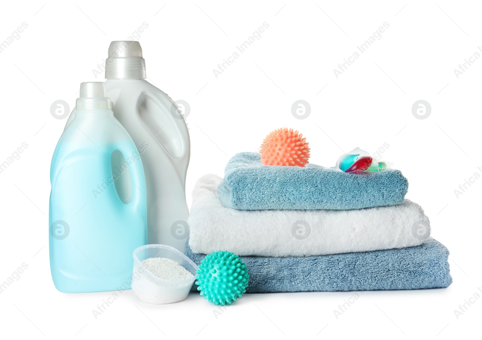 Photo of Color dryer balls, detergents and stacked clean towels on white background
