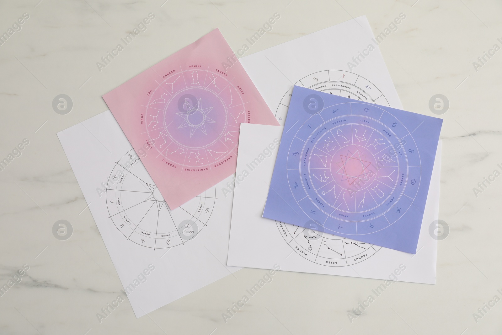 Photo of Zodiac wheels for making forecast of fate on white marble table, top view. Astrological predictions