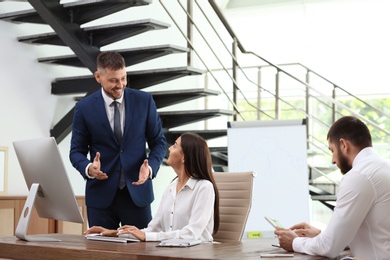 Man helping his colleague with work in office