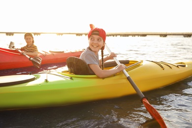 Photo of Little children kayaking on river. Summer camp activity