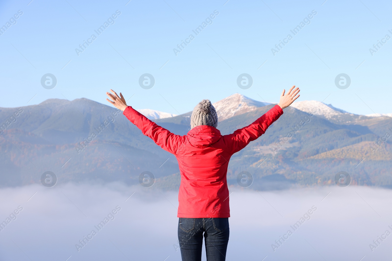 Photo of Woman admiring mountain landscape, back view. Freedom concept