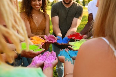 Friends with colorful powder dyes outdoors, closeup. Holi festival celebration