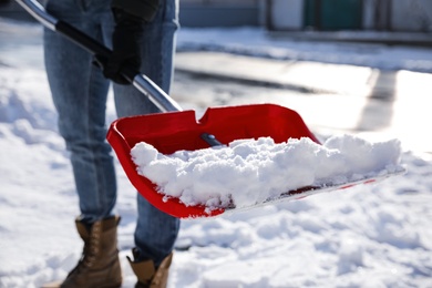 Person shoveling snow outdoors on winter day, closeup