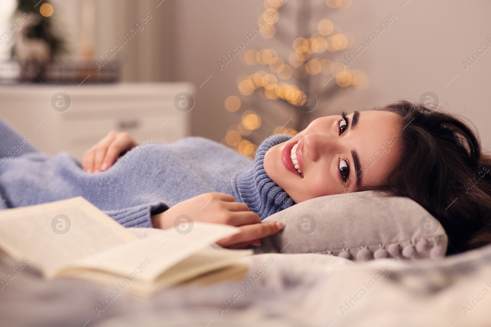 Photo of Young woman in knitted sweater resting at home. Winter atmosphere