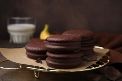Photo of Delicious banana choco pies on wooden table, closeup