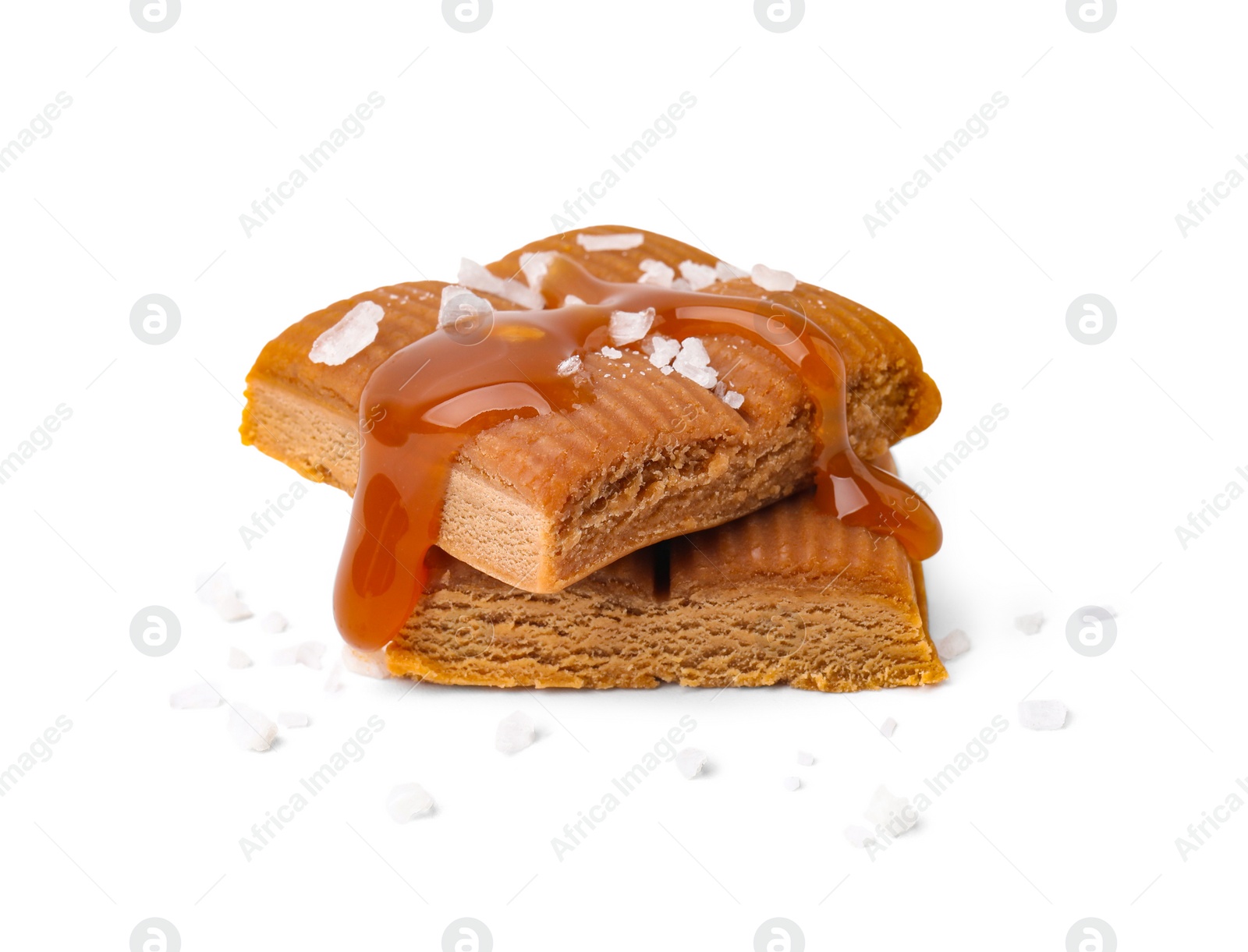 Photo of Yummy caramel candies and sea salt isolated on white