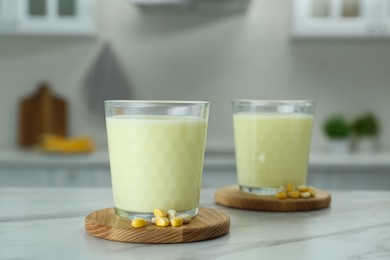 Tasty fresh corn milk in glasses on white table indoors