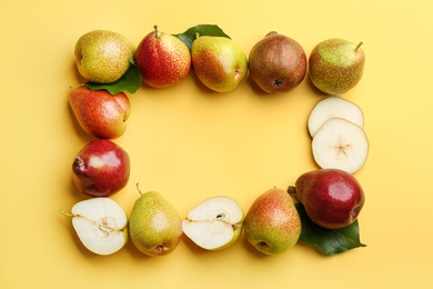 Ripe juicy pears on yellow background, flat lay. Space for text