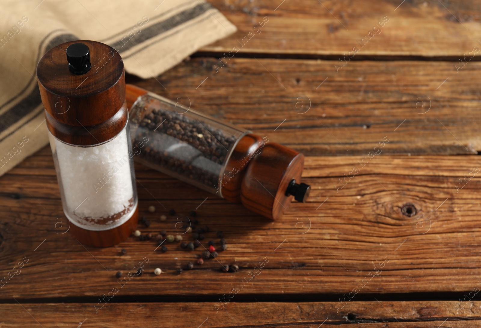 Photo of Salt and pepper shakers on wooden table, space for text