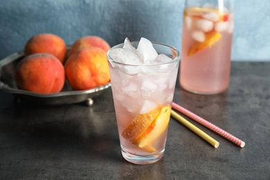 Photo of Tasty peach cocktail on table. Refreshing drink