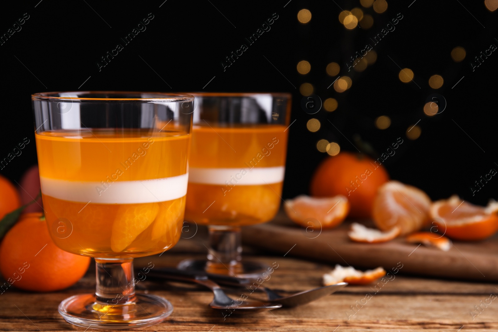 Photo of Delicious tangerine jelly on wooden table. Space for text