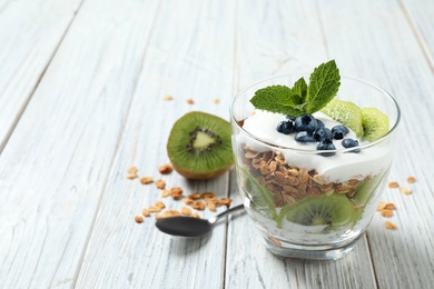 Tasty homemade granola dessert on white wooden table, space for text. Healthy breakfast