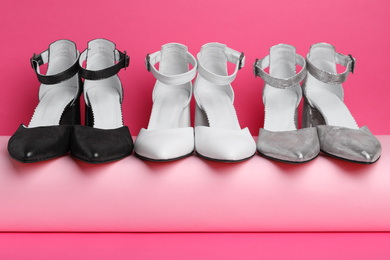 Many stylish female shoes on pink background