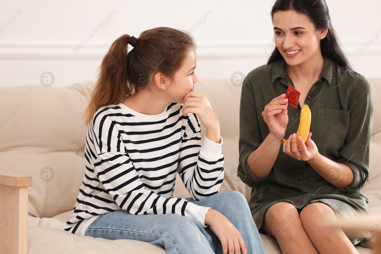 Photo of Mother talking with her teenage daughter about contraception at home. Sex education concept