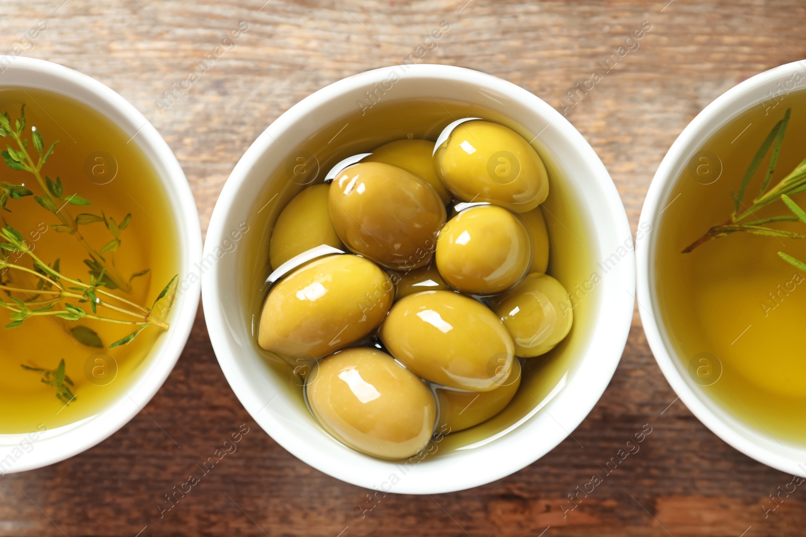 Photo of Bowl with ripe olives in oil on table, top view