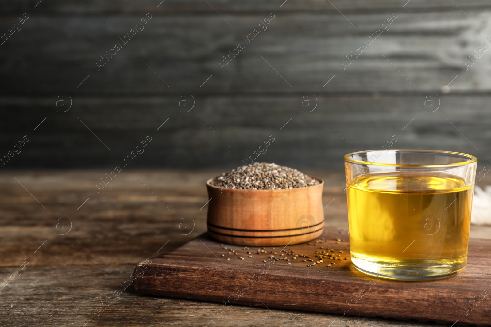 Photo of Composition with chia seeds oil and grains on wooden table. Space for text