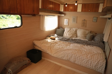 Photo of Stylish room interior with comfortable bed and pillows in modern trailer. Camping vacation