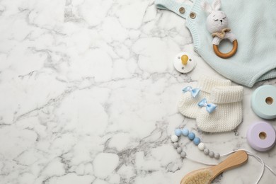 Photo of Cute baby stuff on white marble background, flat lay. Space for text